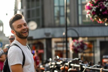 Bir insan bir sırt çantası ile Amsterdam sokaklarında yürüyor.