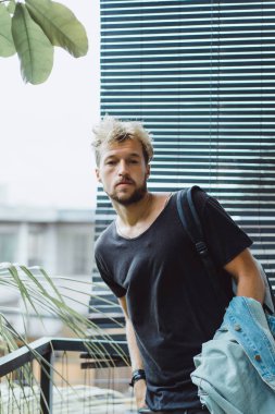 tropikal bir yerde, palmiye ağaçları ve yeşil, güneş gözlüklü bir arka plan üzerinde poz genç çekici adam