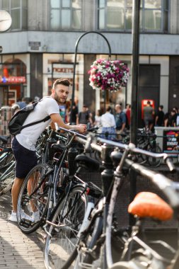 Bir insan bir sırt çantası ile Amsterdam sokaklarında yürüyor.
