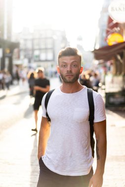 Bir insan bir sırt çantası ile Amsterdam sokaklarında yürüyor.