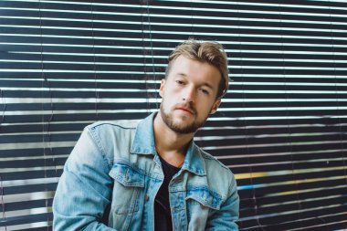 tropikal bir yerde, palmiye ağaçları ve yeşil, güneş gözlüklü bir arka plan üzerinde poz genç çekici adam