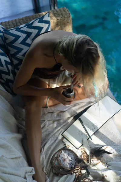 Çatıda mate çay içme uzun sarı saçlı güzel Hint hippi kız. Calabaza