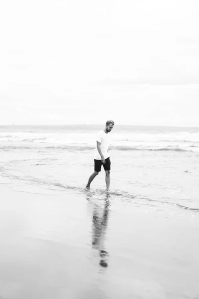 Aantrekkelijke Jongeman Wandelen Langs Het Strand Van Oceaan Een Zandstrand — Stockfoto