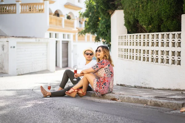 若い幸せなカップルがスペインの小さな通りを歩きシャンパンを飲み笑います — ストック写真