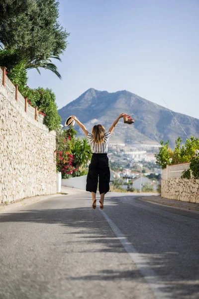tatil atlama genç güzel kadın. Bir elinde ikinci el şapka sandalet.