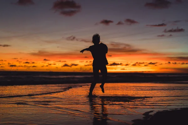 Люди Берегу Океана Закате Человек Прыгает Фоне Заходящего Солнца — стоковое фото