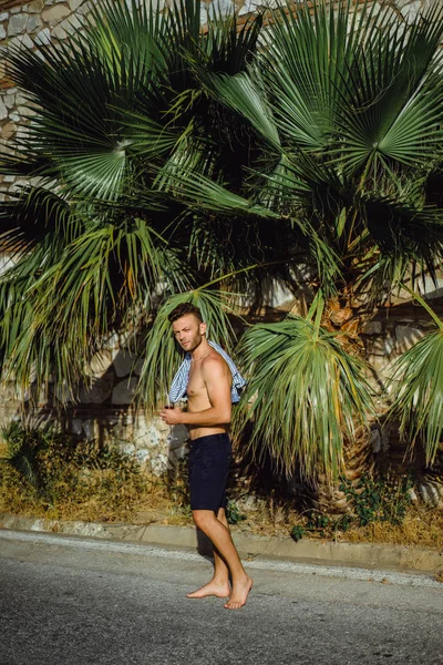 çizgili gömlekli, hasır şapka giyen bir adam, küçük bir İspanyol kasabasının sokaklarında yürüyor..