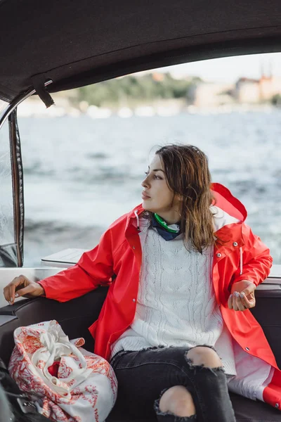 kırmızı bir yağmurluk güzel genç kadın ile özel yat gidiyor. Stockholm, İsveç