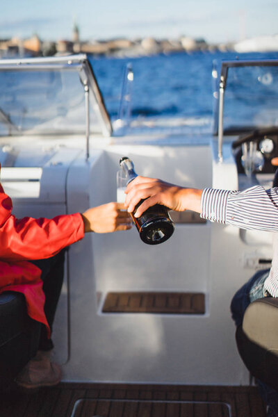 красивая молодая женщина в красном плаще, пьющая шампанское на яхте.