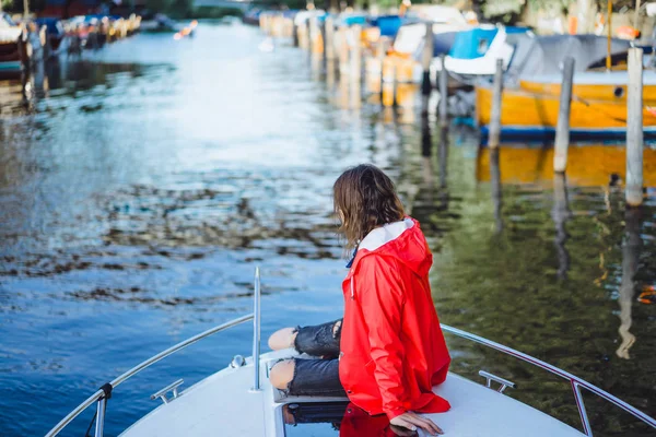 kırmızı bir yağmurluk güzel genç kadın ile özel yat gidiyor. Stockholm, İsveç
