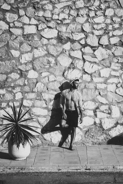 çizgili gömlekli, hasır şapka giyen bir adam, küçük bir İspanyol kasabasının sokaklarında yürüyor..