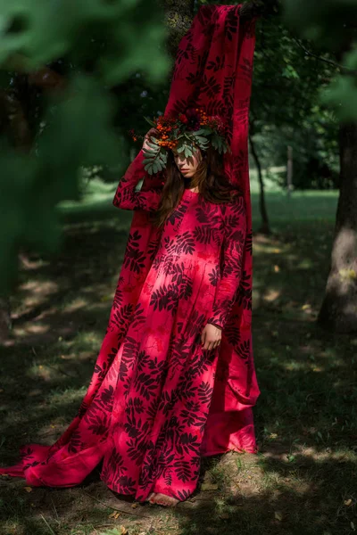 girl in a linen dress. with a wreath of flowers on her head.