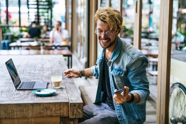 genç çekici iş adamı için bir dizüstü bilgisayar, bir kafe eserlerinde kahve içiyor.