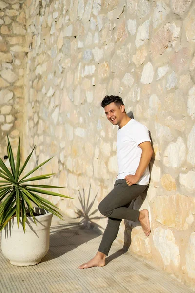 çizgili gömlekli, hasır şapka giyen bir adam, küçük bir İspanyol kasabasının sokaklarında yürüyor..