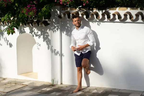 Beyaz gömlekli adam yazın açık havada kahve içer.