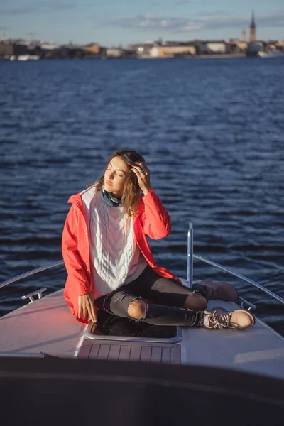 kırmızı bir yağmurluk güzel genç kadın ile özel yat gidiyor. Stockholm, İsveç