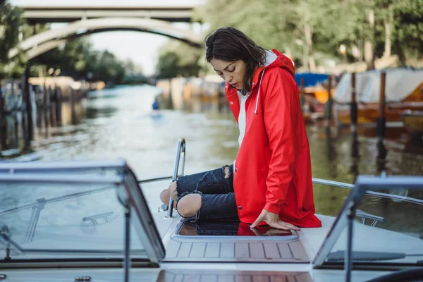 kırmızı bir yağmurluk güzel genç kadın ile özel yat gidiyor. Stockholm, İsveç