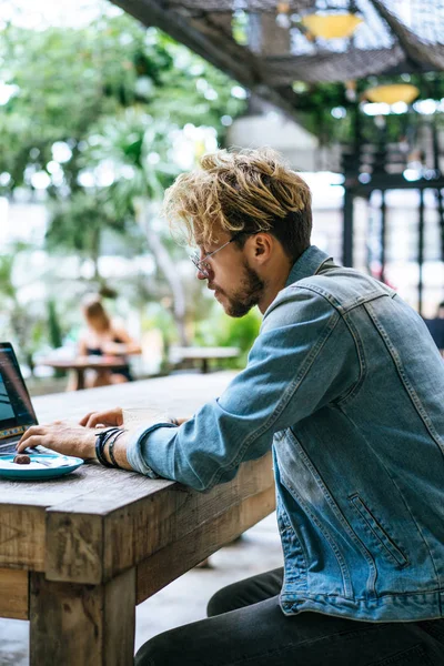 genç çekici iş adamı için bir dizüstü bilgisayar, bir kafe eserlerinde kahve içiyor.