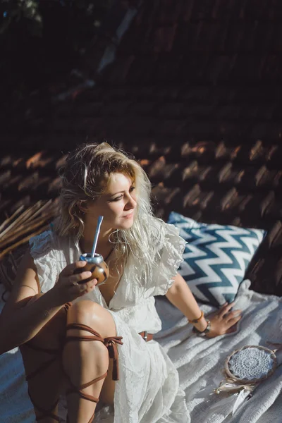 Çatıda mate çay içme uzun sarı saçlı güzel Hint hippi kız. Calabaza