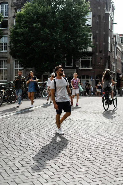 一个背着背包的人在阿姆斯特丹的街道上散步 — 图库照片