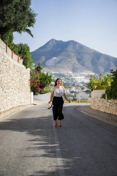 Genç ve güzel bir kadın küçük bir Avrupa kasabasının sokaklarında yürüyor. yaz tatili