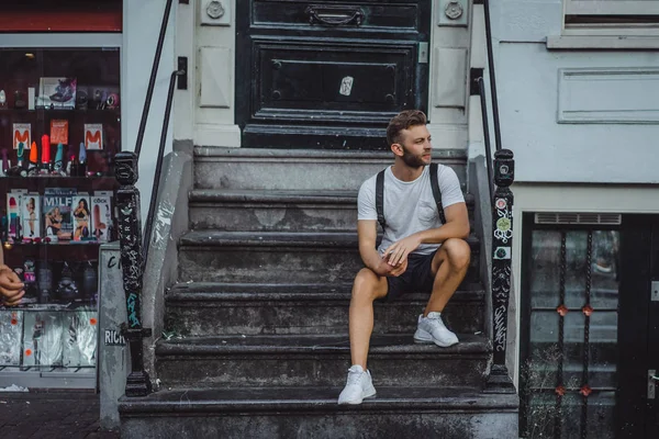 Bir insan bir sırt çantası ile Amsterdam sokaklarında yürüyor.