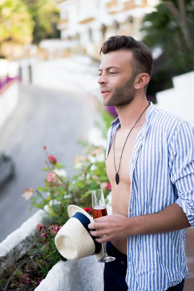 Kadehli gömlekli bir adam. Bir İspanyol kasabasında yaz tatili, açık hava.