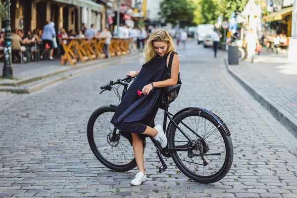 Şehirde bisiklet süren genç bir kadın.