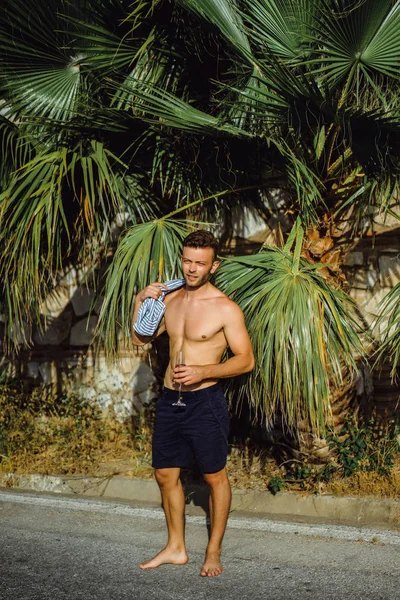 çizgili gömlekli, hasır şapka giyen bir adam, küçük bir İspanyol kasabasının sokaklarında yürüyor..