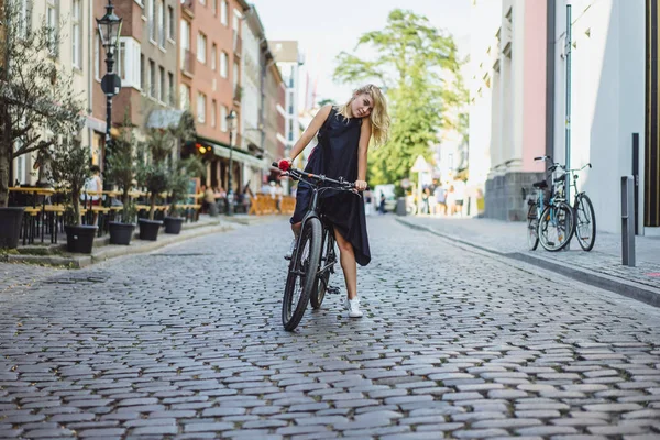 Şehirde bisiklet süren genç bir kadın.