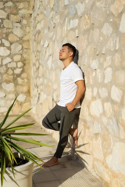 çizgili gömlekli, hasır şapka giyen bir adam, küçük bir İspanyol kasabasının sokaklarında yürüyor..