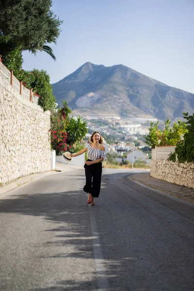 Genç ve güzel bir kadın küçük bir Avrupa kasabasının sokaklarında yürüyor. yaz tatili