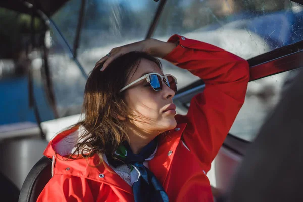 kırmızı bir yağmurluk güzel genç kadın ile özel yat gidiyor. Stockholm, İsveç