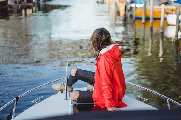 kırmızı bir yağmurluk güzel genç kadın ile özel yat gidiyor. Stockholm, İsveç