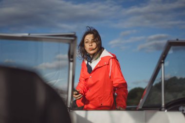 kırmızı bir yağmurluk güzel genç kadın ile özel yat gidiyor. Stockholm, İsveç