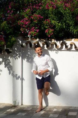 Beyaz gömlekli adam yazın açık havada kahve içer.