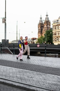 Bir insan bir sırt çantası ile Amsterdam sokaklarında yürüyor.