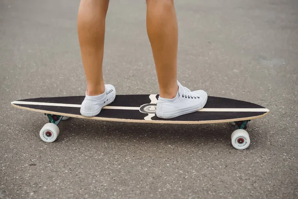 girl with long hair skates on a skateboard. street, active sports