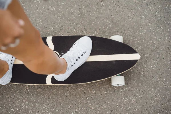 girl with long hair skates on a skateboard. street, active sports
