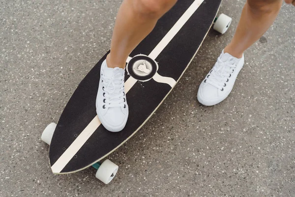 girl with long hair skates on a skateboard. street, active sports