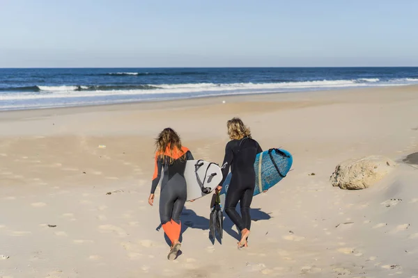 男女はサーフボードを持って海に行きます 男と女の子はサーフィンに行く ポルトガル ナザール ウェットスーツでサーフィン — ストック写真