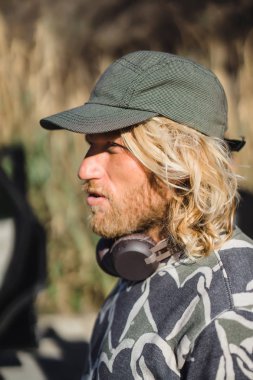 Beyzbol şapkalı, uzun beyaz saçlı adam mesafe içine bir portre seyir. sörfçü.