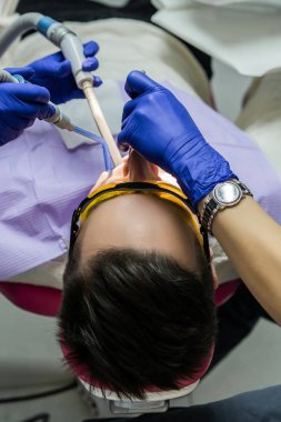 diş hekimi resepsiyonda genç adam. Diş ofis, profesyonel ağız hijyeni, diş hekimi muayenesi.