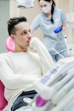 diş hekimi resepsiyonda genç adam. Diş ofis, profesyonel ağız hijyeni, diş hekimi muayenesi.