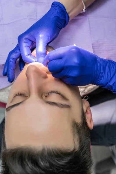 young man at the reception at the dentist. Dental office, professional oral hygiene, dentist examination.