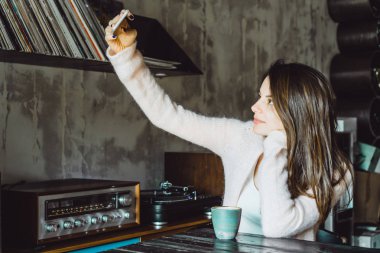 büyüleyici bir gülümseme ve kahve içme ve bir smartphone kullanarak ifade kahverengi gözlü güzel bir esmer kız