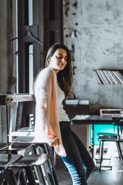 büyüleyici bir gülümseme ve bir iç çatı katı tarzında bir kafede kahve içme ifade kahverengi gözlü güzel esmer kız