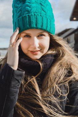 güzel sarışın kız mavi gözleri ve uzun saçlı bir sıcak yeşil örme şapka yakın çekim portre