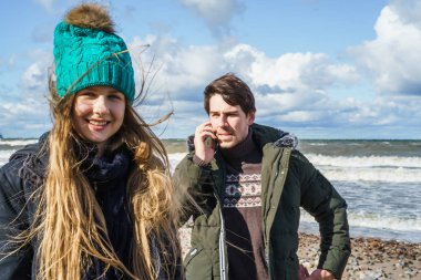 genç bir çift hafta sonları deniz kenarı soğuk Baltık Denizi, kumsalı, sıcak ceketler, Aile hafta sonu erkek ve kadın plajda çalışan harcama aşık.