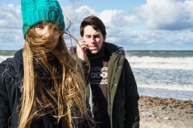 genç bir çift hafta sonları deniz kenarı soğuk Baltık Denizi, kumsalı, sıcak ceketler, Aile hafta sonu erkek ve kadın plajda çalışan harcama aşık.